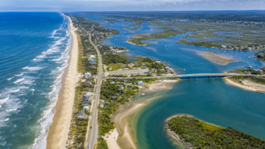 Aerial drone view of Crescent Beach, Matanzas Inlet, and the scenic A1A South corridor near St. Augustine, Florida featuring pristine beaches, coastal marshes, oceanfront homes, beach access points, and the iconic Matanzas Bridge