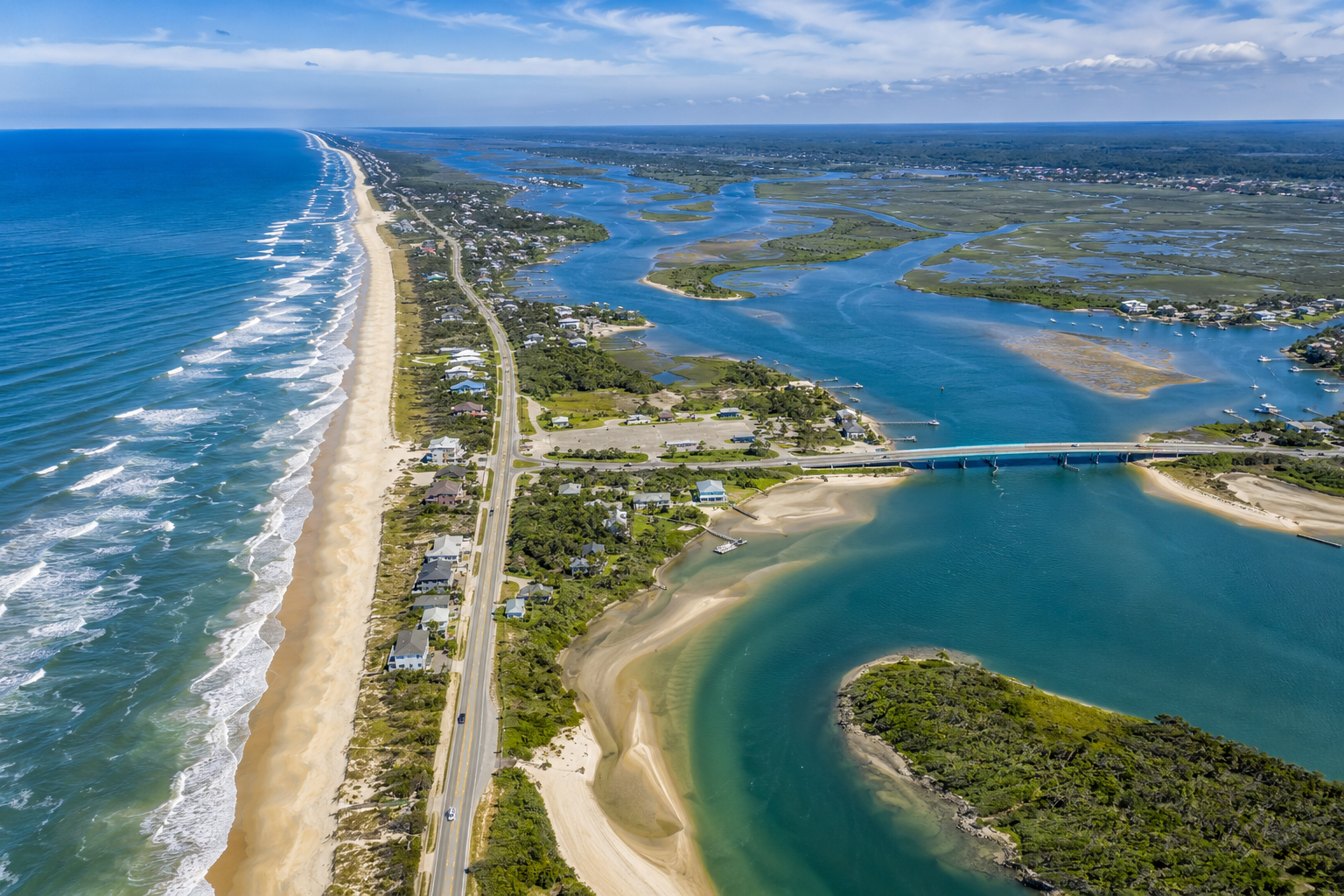 Aerial drone view of Crescent Beach, Matanzas Inlet, and the scenic A1A South corridor near St. Augustine, Florida featuring pristine beaches, coastal marshes, oceanfront homes, beach access points, and the iconic Matanzas Bridge
