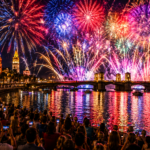 Spectacular Fourth of July fireworks explode over the waterfront of St. Augustine as thousands of spectators gather along the historic bayfront to watch the colorful display above the Bridge of Lions and Matanzas Bay, with vibrant reflections shimmering across the water and the city's historic skyline glowing in the background